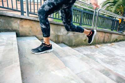 Female legs wearing leggings training running up stairs in town