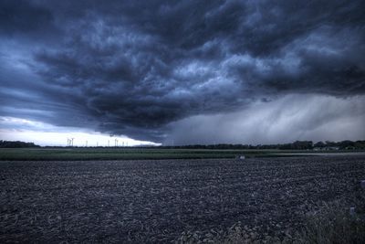 Scenic view of field against cloudy sky