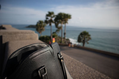 Close-up of shoes on beach against sky