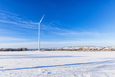 Scenic view of snow covered field against clear blue sky