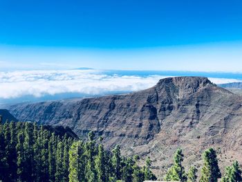 Scenic view of mountains against blue sky