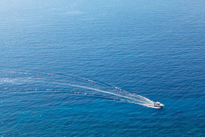 Boat on an offshore sailing . vessel speeding on the blue sea