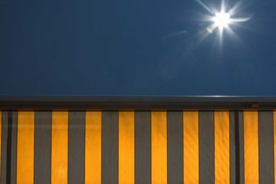 Low angle view of illuminated built structure against blue sky