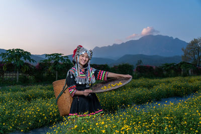 Woman standing on field by mountain against sky