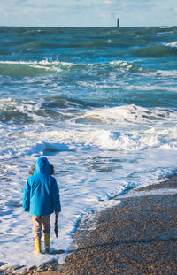 Rear view of man walking on beach