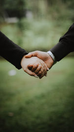 Midsection of couple holding hands