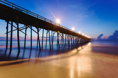 Bridge over sea against sky during sunset