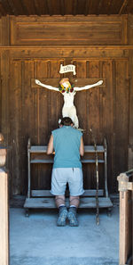 Full length of man praying while kneeling on bench