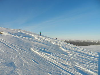 Tourists on snow covered landscape