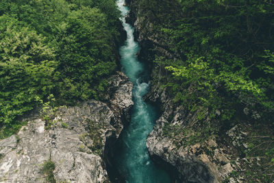 High angle view of river flowing amidst rock formations in forest