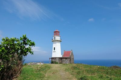 Lighthouse by sea against sky