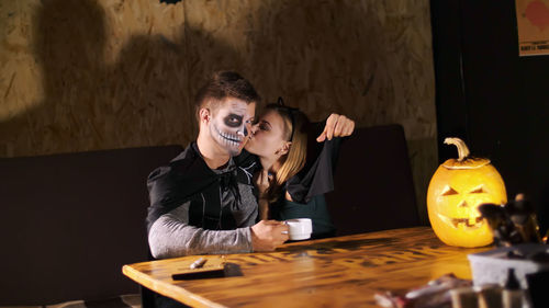 Date in style of halloween party, night, twilight, in the rays of light, guy with a girl dressed