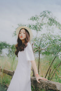 Portrait of beautiful young woman standing on land