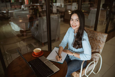Businesswoman using laptop while sitting at cafe