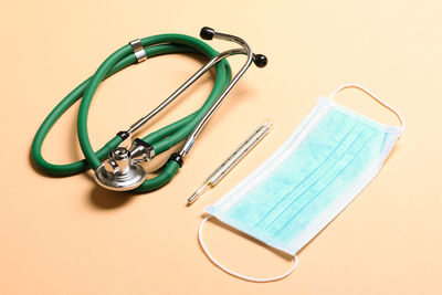 High angle view of stethoscope against pink background