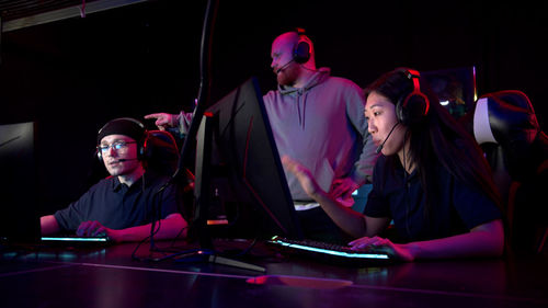 People playing video game in darkroom