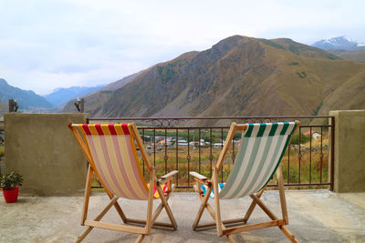 Pair of empty deck chairs at the veranda against beautiful mountain view