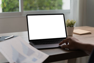 Cropped hands using laptop on table