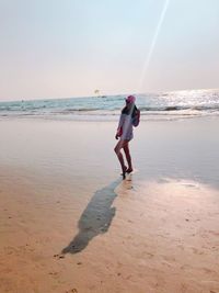 Full length of woman on beach against sky