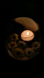 High angle view of illuminated candle against black background