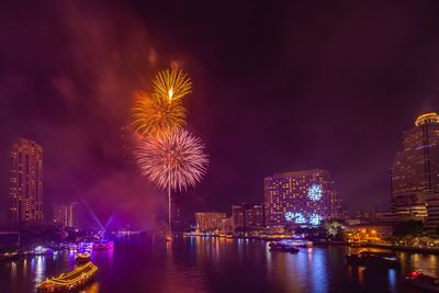 Firework display over river at night