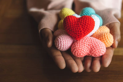 Cropped hands holding knitted heart shapes