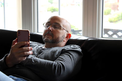 Man using mobile phone while sitting at home