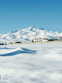 Scenic view of snowcapped mountains against clear blue sky