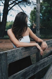 Woman sitting on wooden railing