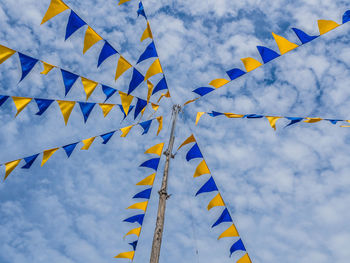 Low angle view of flags against sky