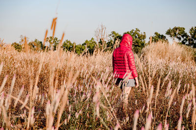 Rear view of woman walking on field