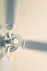 Close-up of electric lamp on wall at home