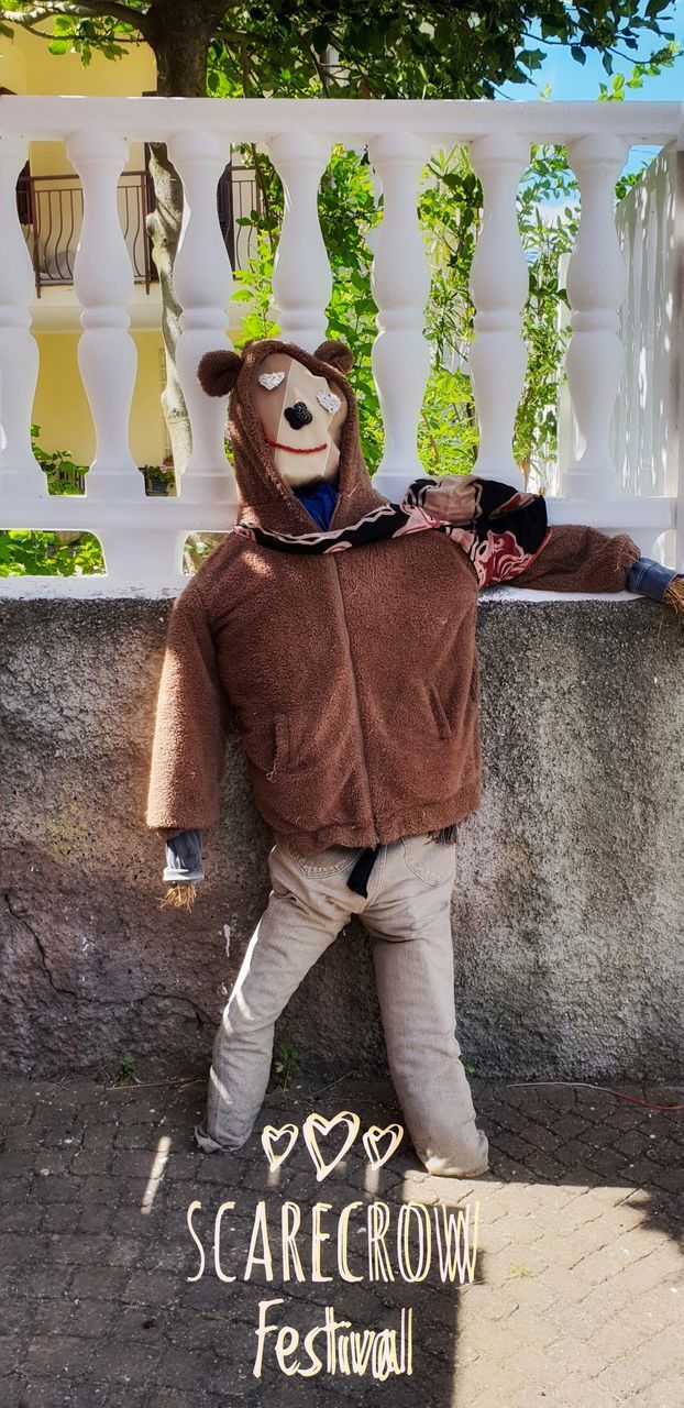 FULL LENGTH OF MAN WEARING MASK STANDING AGAINST WALL