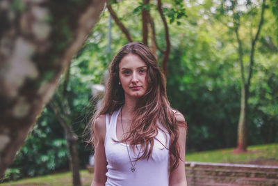 Portrait of young woman standing in forest