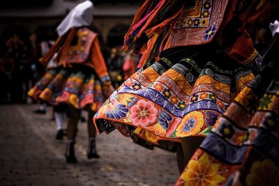 Women wearing traditional clothing while dancing on footpath