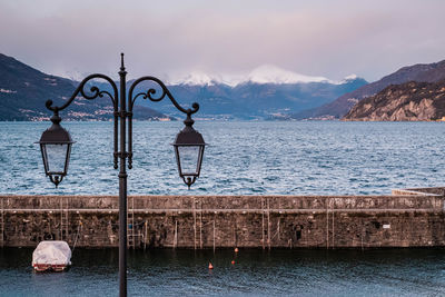 A lonely boat in the harbour worth lantern and snowy mountain panorama.