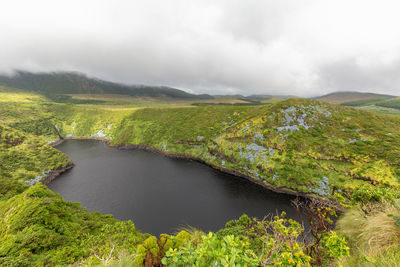 Scenic view of lake by mountain against sky