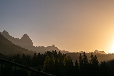 Scenic view of silhouette mountains against clear sky at sunrise 