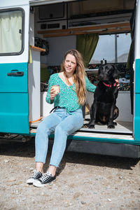 Woman sitting with dog in camper van