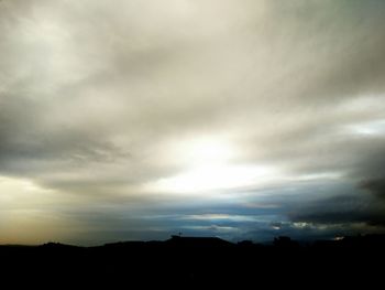 Silhouette of landscape against cloudy sky