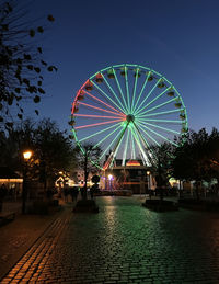Illuminated ferris wheel against sky at night