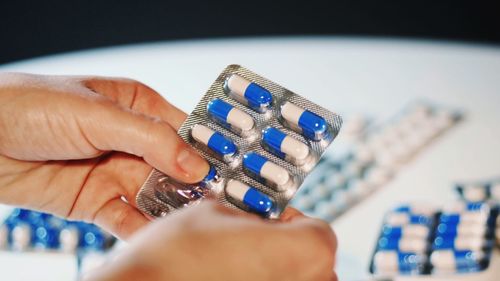 Cropped hands of person holding pill blister