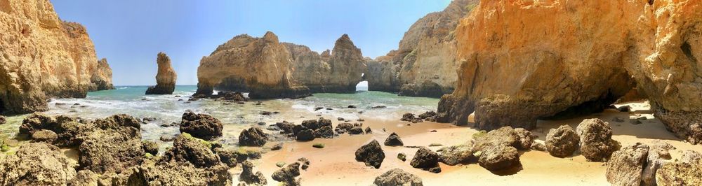 Panoramic view of rocks on beach against sky