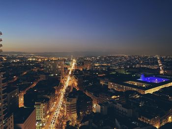 High angle view of illuminated city buildings against clear sky