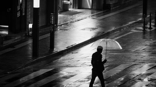 Man walking on wet street during rainy season