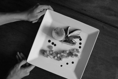 Cropped hands having food at table