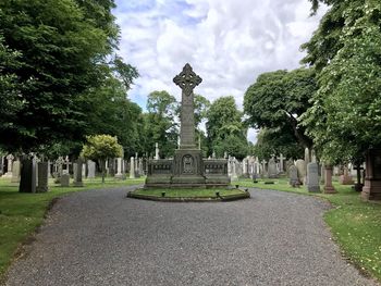 Trees in cemetery against sky