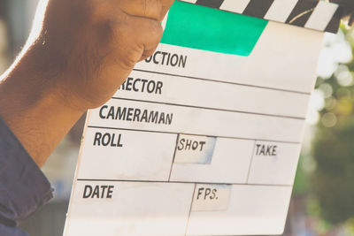 Close-up of man holding clapper board