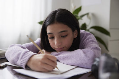 Girl doing homework at dining table