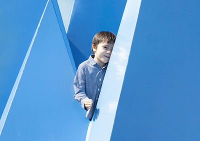 Portrait of cute boy standing by wall